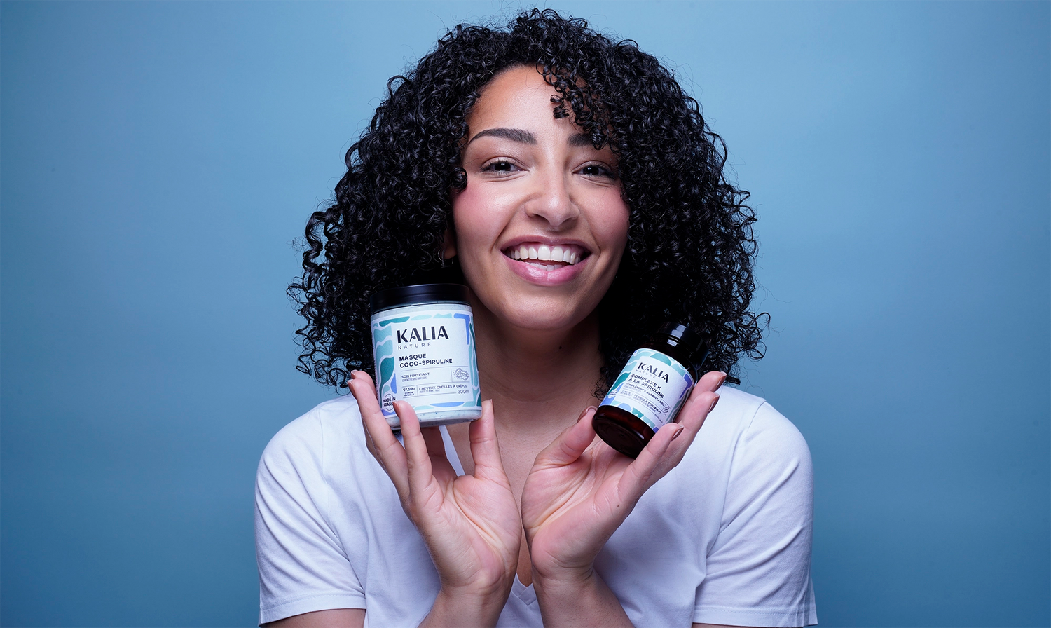 Photo modèle aux cheveux bouclés avec la routine In & Out Kalia Nature, comprenant le Complexe K à la spiruline et le Masque Coco-Spiruline