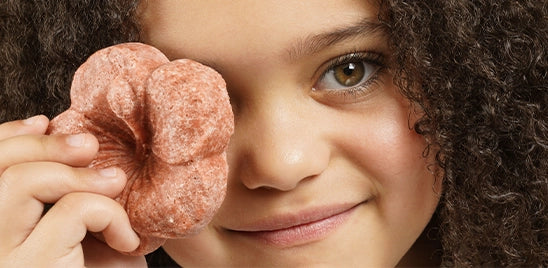 photo d'une petite fille avec le shampoing solide en forme d’hibiscus 