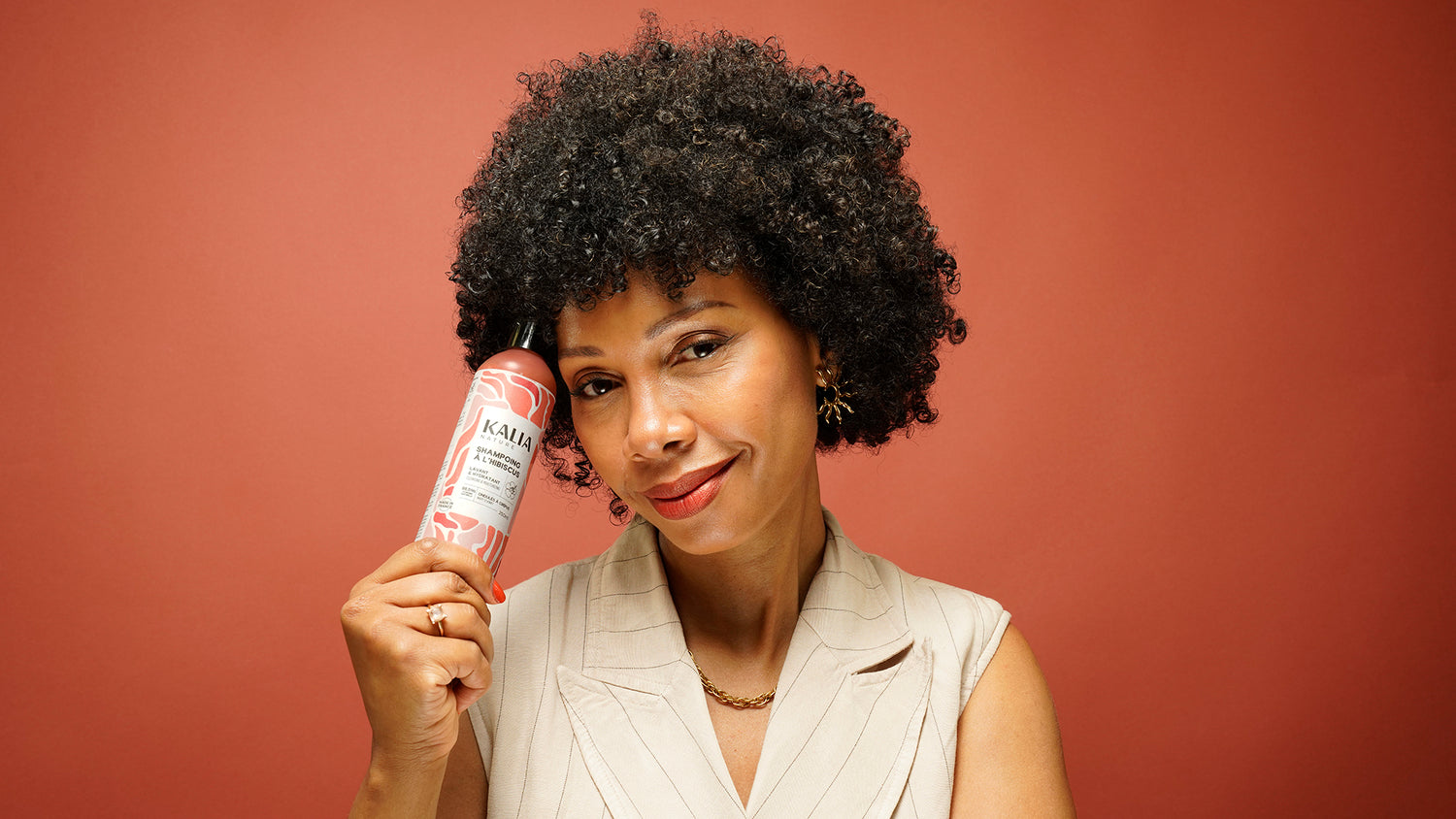 Photo de Sandrine Sophie, fondatrice de la marque Kalia Nature – elle tient l’une des nouveautés : le shampoing à l’hibiscus